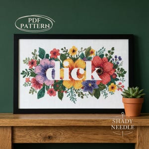 Peut inclure: Une broderie au point de croix encadrée en noir avec le mot "dick" en blanc, entouré de fleurs colorées. Les fleurs comprennent des fleurs rouges, jaunes, violettes et roses. Les mots "PDF PATTERN" et "SHADY NEEDLE" sont également visibles.
