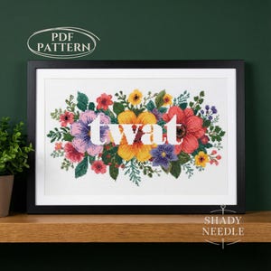 May include: Framed cross-stitch artwork with the word "twat" in white, set against a backdrop of colourful flowers. The floral arrangement includes pink, red, yellow, and purple blooms. The words "PDF PATTERN" and "SHADY NEEDLE" are also visible.