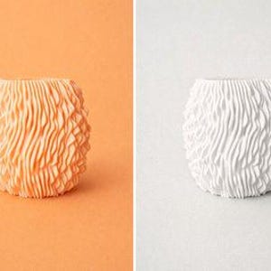 Könnte beinhalten: Zwei dekorative Vasen mit einem strukturierten, geriffelten Design. Eine Vase ist in einem weichen Orangeton gehalten, die andere ist weiß. Die Vasen haben eine einzigartige, organische Form und stehen vor kontrastierenden Hintergründen.