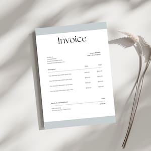 May include: A minimalist invoice template with the title "Invoice" in a stylish font. The document has a light blue header and footer, with sections for item descriptions, prices, and totals. A sprig of dried flowers rests beside the document.