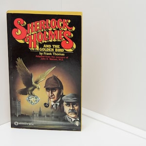 May include: A book cover featuring an illustration of Sherlock Holmes and a golden bird. The title is "Sherlock Holmes and the Golden Bird" by Frank Thomas. The text "Adapted from the memoirs of John H. Watson, M.D." is also included.