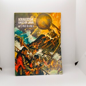 May include: A vintage movie poster for the film "Krakatoa, East of Java" in Cinerama. The poster features a dramatic scene of a volcanic eruption with a hot air balloon in the sky and people on a ship.