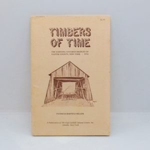 May include: A softcover book titled Timbers of Time, The Existing Covered Bridges of Ulster County, New York - 1976 by Patricia Bartels Miller. The cover is light tan with brown text and a line drawing of a wooden covered bridge in the center.