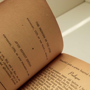 May include: Close-up of the copyright page of a vintage paperback book titled "The Princess of the Atom". The book was published in 1929 by The Frank A. Munsey Co. and reprinted in 1950 by Avon Publishing Co.
