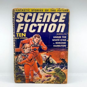 May include: A vintage science fiction magazine cover featuring a blue background with the title "Science Fiction" in white lettering. The cover depicts two astronauts in red space suits, one female and one male, standing on a rocky surface with a green alien creature in the foreground. The text "Ten New Stories" and "Under the White Star by Edmond Hamilton" is also visible.