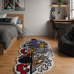 May include: A custom-shaped rug with a cartoon illustration of a sword, lightning bolt, and a smiling face. The rug has a white border and features red, purple, yellow, and grey colours. It is placed on a wooden floor.