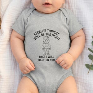 May include: A gray baby bodysuit with short sleeves. The front of the bodysuit features a black and white cartoon graphic of a person with the text "BECAUSE TONIGHT WILL BE THE NIGHT THAT I WILL BARF ON YOU."