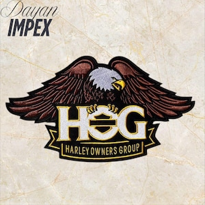 May include: Embroidered patch featuring a detailed eagle with outstretched wings, in shades of brown, black, white, and yellow. The patch includes the text "HOG HARLEY OWNERS GROUP" in white and gold, with the Harley-Davidson logo. The text "Dayan IMPEX" is at the top.