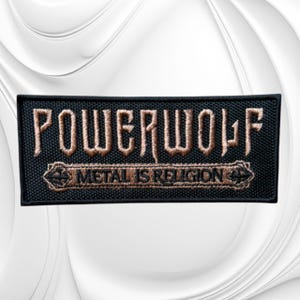 May include: A rectangular black embroidered patch featuring the word POWERWOLF in large, stylized tan lettering. Below the band name, a smaller tan banner contains the text METAL IS RELIGION, flanked by small cross symbols on each side.