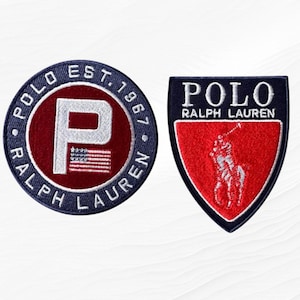 May include: Two embroidered patches. One is circular with "POLO RALPH LAUREN EST. 1967" around a red center with a white "P" and American flag. The other is shield-shaped with "POLO RALPH LAUREN" and a polo player.
