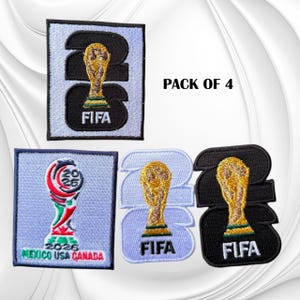 May include: A pack of 4 embroidered patches featuring the FIFA 2026 World Cup logo. The designs include the number 2026 with a gold trophy, the official tournament emblem with the text MEXICO USA CANADA, and the text PACK OF 4.