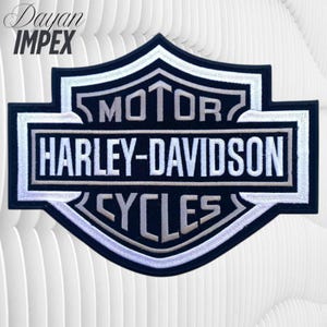 May include: A black and white Harley-Davidson Cycles patch with the text "MOTOR" above "HARLEY-DAVIDSON" and "CYCLES". The patch has a shield shape with a silver border and is set against a white background.