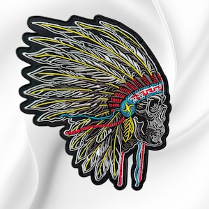 May include: An embroidered patch featuring a skull wearing a large feathered headdress. The design uses black, white, yellow, red, and blue thread to create detailed textures on the feathers and the skull, finished with a solid black border.