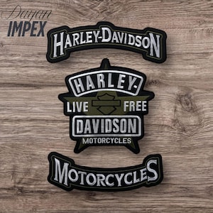 May include: Three Harley-Davidson embroidered patches. The top patch reads "HARLEY-DAVIDSON" in white lettering on a black background. The middle patch has "HARLEY" above "LIVE FREE DAVIDSON MOTORCYCLES". The bottom patch reads "MOTORCYCLES".