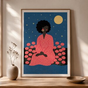Puede incluir: Una lámina artística enmarcada que muestra a una persona de piel oscura y cabello rizado con un vestido rojo de lunares. La figura está sentada entre flores rosas sobre un cielo nocturno azul oscuro con una luna amarilla y estrellas.