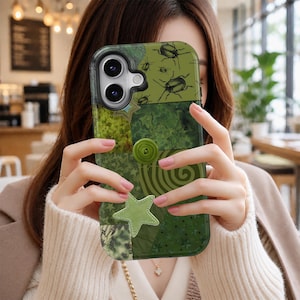 Może przedstawiać: Zielone etui na smartfona z kolażem w różnych odcieniach zieleni, zawierające wzory chrząszczy, spirali i gwiazd. Etui ozdobione jest centralnym okrągłym zielonym guzikiem oraz jasnozieloną aplikacją w kształcie gwiazdy z tkaniny w dolnej części.