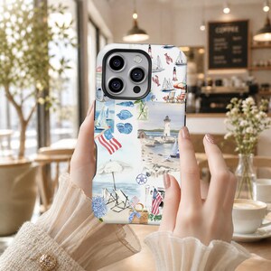 May include: A phone case featuring a collage of nautical and coastal illustrations, including sailboats, a lighthouse, American flags, beach chairs, seashells, a picnic basket, and blue hydrangeas on a white background with a black camera cutout.