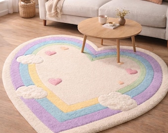 May include: A heart-shaped rug with a pastel rainbow design. The rug has a cream-coloured centre, bordered by yellow, green, blue, and purple stripes. White cloud and pink heart accents are also featured.