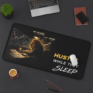 May include: Black rectangular desk mat with a lion graphic working on a computer. The mat has the words "NO EXCUSES", "GRIND", and "HUSTLE WHILE THEY SLEEP". A computer mouse and a cup of coffee are also visible.