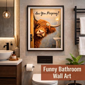 Puede incluir: Un cuadro de pared enmarcado que muestra una vaca Highland marr&oacute;n de pelaje desgre&ntilde;ado asom&aacute;ndose por una puerta con el texto Are You Pooping? escrito encima. La vaca tiene una peque&ntilde;a margarita blanca detr&aacute;s de su cuerno.