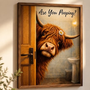 Puede incluir: Un cuadro enmarcado que muestra a una vaca Highland de pelaje rojizo y alborotado asom&aacute;ndose por una puerta de madera hacia un ba&ntilde;o alicatado. La vaca tiene una peque&ntilde;a margarita blanca tras el cuerno. El texto Are You Pooping? aparece en negro.