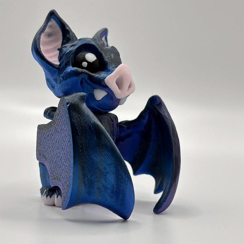 A free-standing, posable 3D Printed Vampire Bat, created with blue-black & purple silk pla for a soft shine.