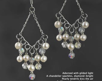 May include: Silver dangle earrings with a chandelier design featuring white pearls and clear crystals.