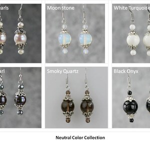 May include: A collection of neutral colored earrings with silver accents. The earrings feature a variety of stones and pearls, including white pearls, moonstone, white turquoise, black pearl, smoky quartz, and black onyx.