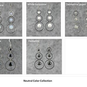 May include: A set of six pairs of dangle earrings featuring different neutral colored stones. The stones are arranged in a graduated size from largest to smallest. The earrings are labeled with the stone names: Moonstone, White Turquoise, Dalmatian Jasper, Black Onyx, Hematite. The text "Neutral Color Collection" is at the bottom of the image.
