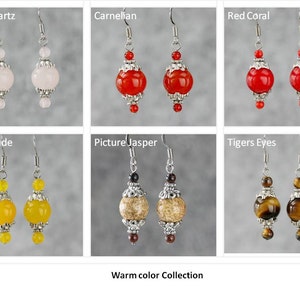 May include: A collection of warm-colored gemstone earrings. The earrings feature a variety of stones, including rose quartz, carnelian, red coral, yellow jade, picture jasper, and tiger's eye. Each pair of earrings is made with silver-toned metal and features a round gemstone bead.