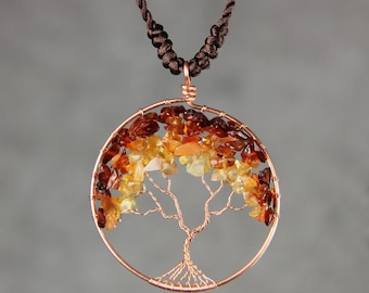 May include: A copper wire tree of life pendant necklace with amber stones. The necklace is on a brown cord.