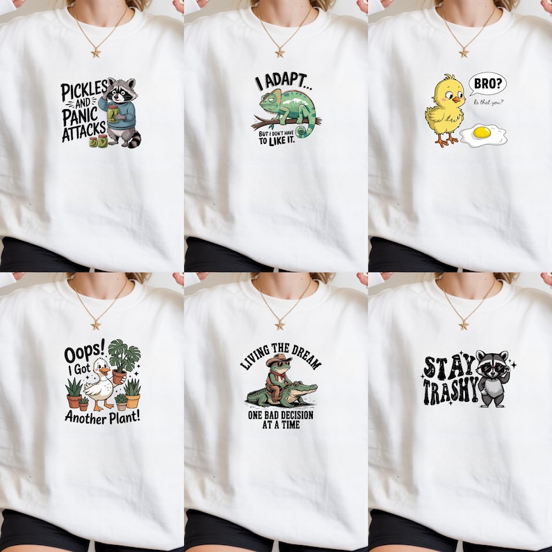 May include: Six white crewneck sweatshirts, each featuring a unique graphic print: a raccoon with pickles, a chameleon, a chick looking at an egg, a duck with potted plants, a frog riding an alligator, and a raccoon with the text Stay Trashy.