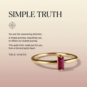 Op de afbeelding: Een gouden ring met een enkele rechthoekige, baguette-geslepen rode edelsteen. De afbeelding bevat de tekst SIMPLE TRUTH, een kompasicoon en de tekst: You are the unwavering direction. A simple promise, beautifully set, to reflect our shared journey. This quiet truth, made just for you, from a full and joyful heart. TRUE NORTH.