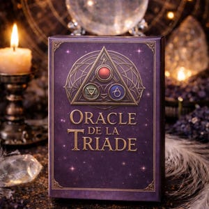 Op de afbeelding: Een paarse Oracle-kaartspeldoos met gouden accenten en de tekst "Oracle de la Triade". De doos heeft een geometrisch ontwerp met rode, blauwe en groene cirkels. Een brandende kaars en een kristallen bol staan op de achtergrond.