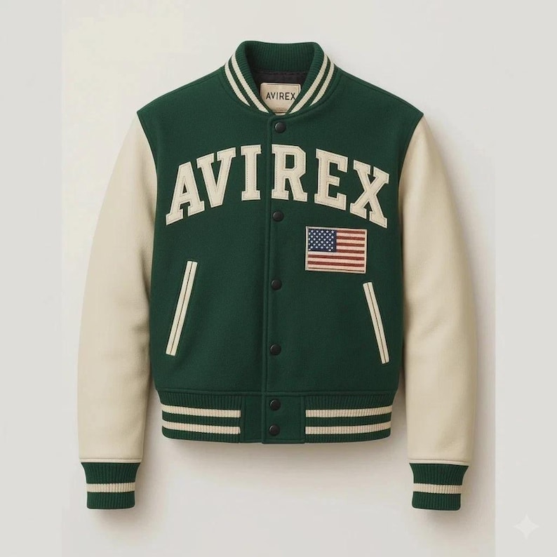 May include: Green and cream-colored letterman jacket with the word "AVIREX" in large white letters across the chest. An American flag patch is on the right chest. The jacket has a button-up front and striped cuffs and hem.