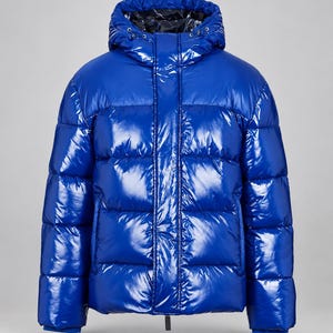 Puede incluir: Una chaqueta acolchada de color azul brillante con un acabado de alto brillo. Este abrigo cuenta con una cremallera frontal completa, una capucha con forro interior oscuro y compartimentos horizontales que le dan un aspecto estructurado.