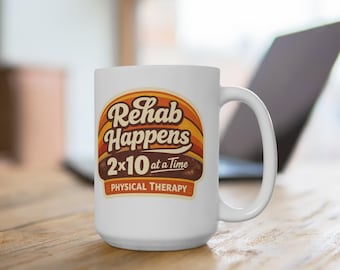 Puede incluir: Una taza de cerámica blanca con un gráfico de rayas curvas en naranja, amarillo y marrón. El texto "Rehab Happens 2x10 at a Time" y "PHYSICAL THERAPY" aparece en una fuente de color marrón oscuro en el frente.
