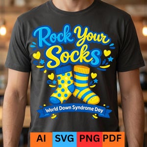 Może przedstawiać: Ciemnoszara koszulka z napisem "Rock Your Socks" w kolorze niebieskim i żółtym. Koszulka przedstawia dwie skarpetki, jedną niebieską w żółte grochy, a drugą żółtą w niebieskie paski. Zawiera również napis "World Down Syndrome Day".