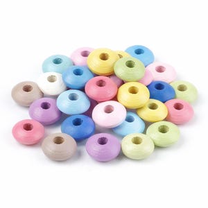 May include: A collection of colorful wooden beads in various pastel shades, including pink, blue, yellow, green, and purple. Each bead is donut-shaped with a central hole, perfect for crafting and jewelry making.