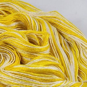 May include: A skein of yellow and white yarn. The yarn is a blend of two colors, creating a striped effect.