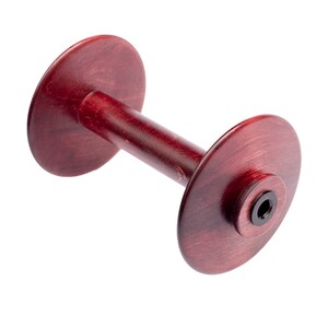 May include: A wooden dumbbell-shaped object with a deep red stain. The dumbbell has two circular ends connected by a cylindrical handle. The ends have a slightly raised center with a black insert. The wood grain is visible.