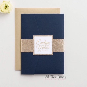 May include: Navy blue wedding invitation with a gold glitter band and a white square with the text "Evelyn and Marco July 19, 2015" in gold script.