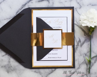 May include: Black and gold wedding invitation with a gold ribbon and a white carnation flower. The invitation includes the couple's names, the date, and the dinner menu.