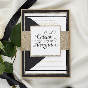 May include: Elegant wedding invitation with a black and gold glitter design. The invitation features the names "Caleigh and Alexander" in elegant script. A black ribbon and white roses are in the background.