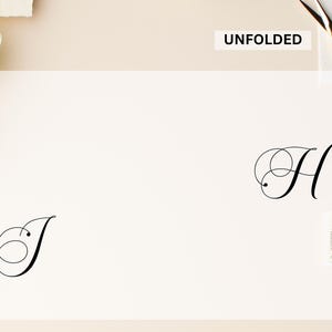 Puede incluir: Una tarjeta blanca con la palabra "UNFOLDED" impresa. La tarjeta presenta las letras estilizadas "J" y "H" en escritura negra. Se ven unas tijeras doradas y un sello postal.