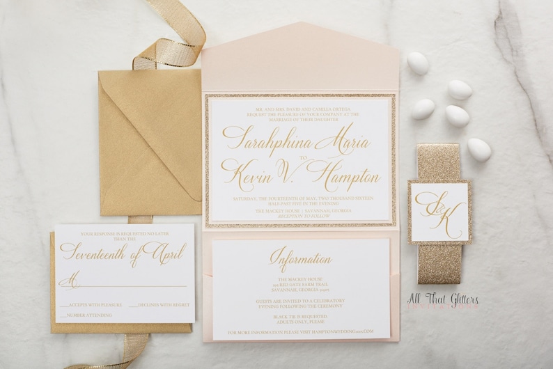 May include: A blush pink and gold wedding invitation suite with a gold glitter border. The invitation features the names "Sarahphina Maria" and "Kevin V. Hampton" in gold script font. The RSVP card says "Seventeenth of April".