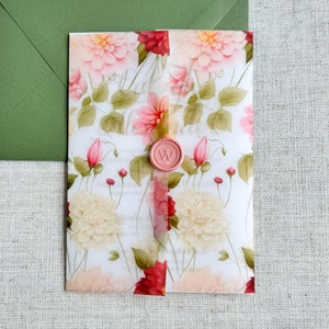 May include: A white invitation card with a floral design featuring pink, red, and cream flowers. The card has a pink wax seal with a letter "W" on it.
