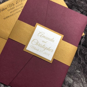 May include: Burgundy and gold wedding invitation with the names Amanda and Christopher and the date March 17, 2018.
