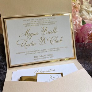May include: A wedding invitation with gold accents. The invitation is for the wedding of Hogan Brielle to Austin B. Clark. The wedding will take place on Saturday, April 13, 2019 at 5:30 PM at The Deroo Home in Winter Garden, Florida.