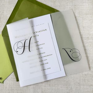 Puede incluir: Conjunto de invitaci&oacute;n de boda con una tarjeta blanca, texto negro y una gran inicial "H" sobre una superposici&oacute;n transl&uacute;cida. Incluye un sobre verde y una tarjeta verde claro. El texto dice "detalles de la celebraci&oacute;n".